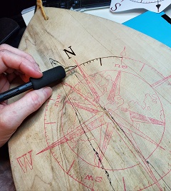 compass image traced for wood burning on cutting board using saral tracing paper